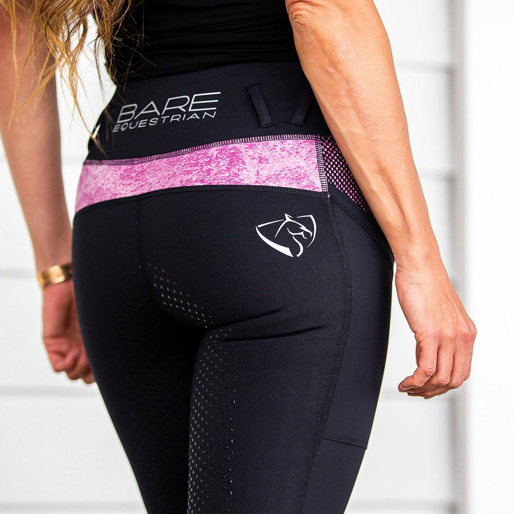 Close-up of black and pink horse riding tights on a woman.