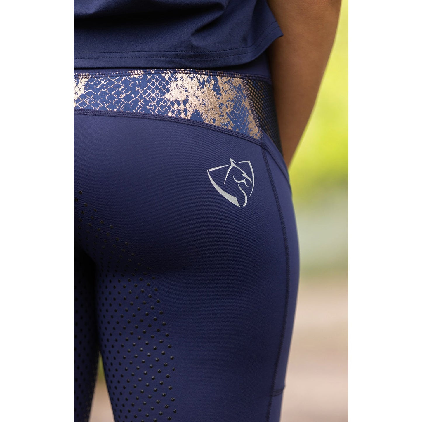 Close-up of navy blue horse riding tights with logo detail.