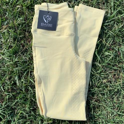 New beige horse riding tights on grass with brand tag visible.
