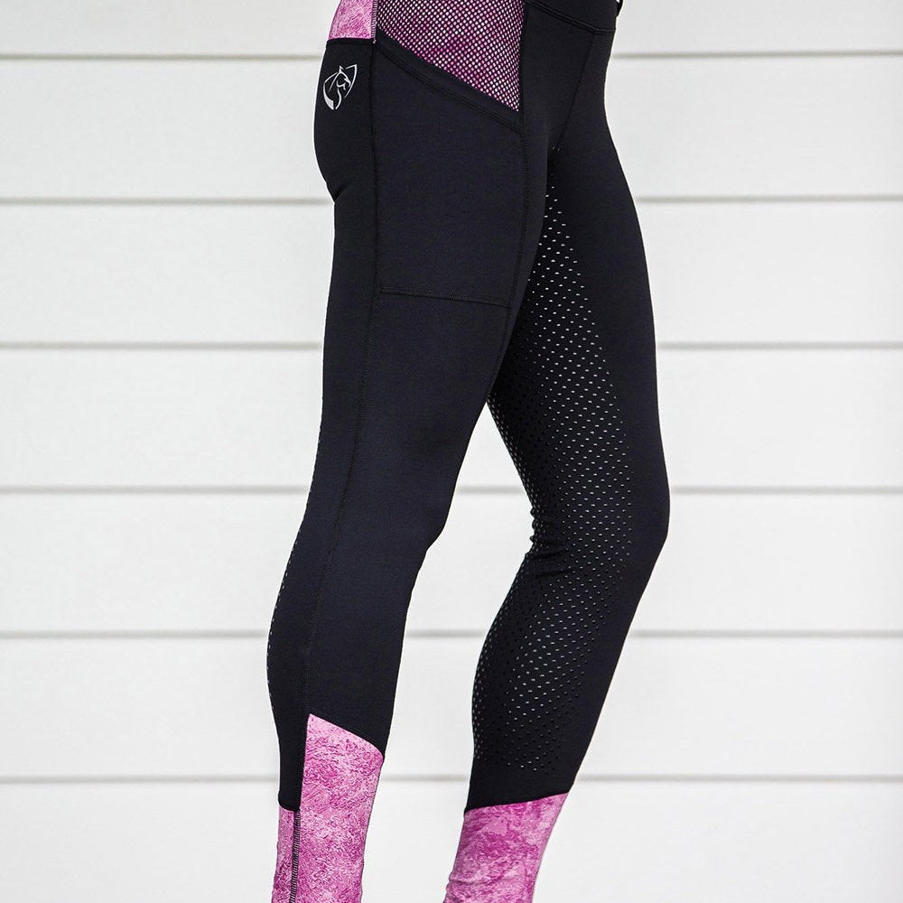 Woman wearing black and pink horse riding tights against white background.