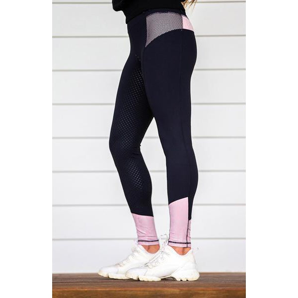 Person standing side view wearing horse riding tights with mesh detail.
