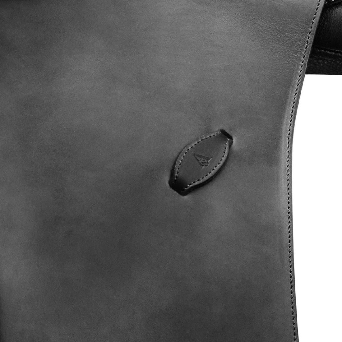 Close-up of Arena Saddles leather logo on black saddle surface.
