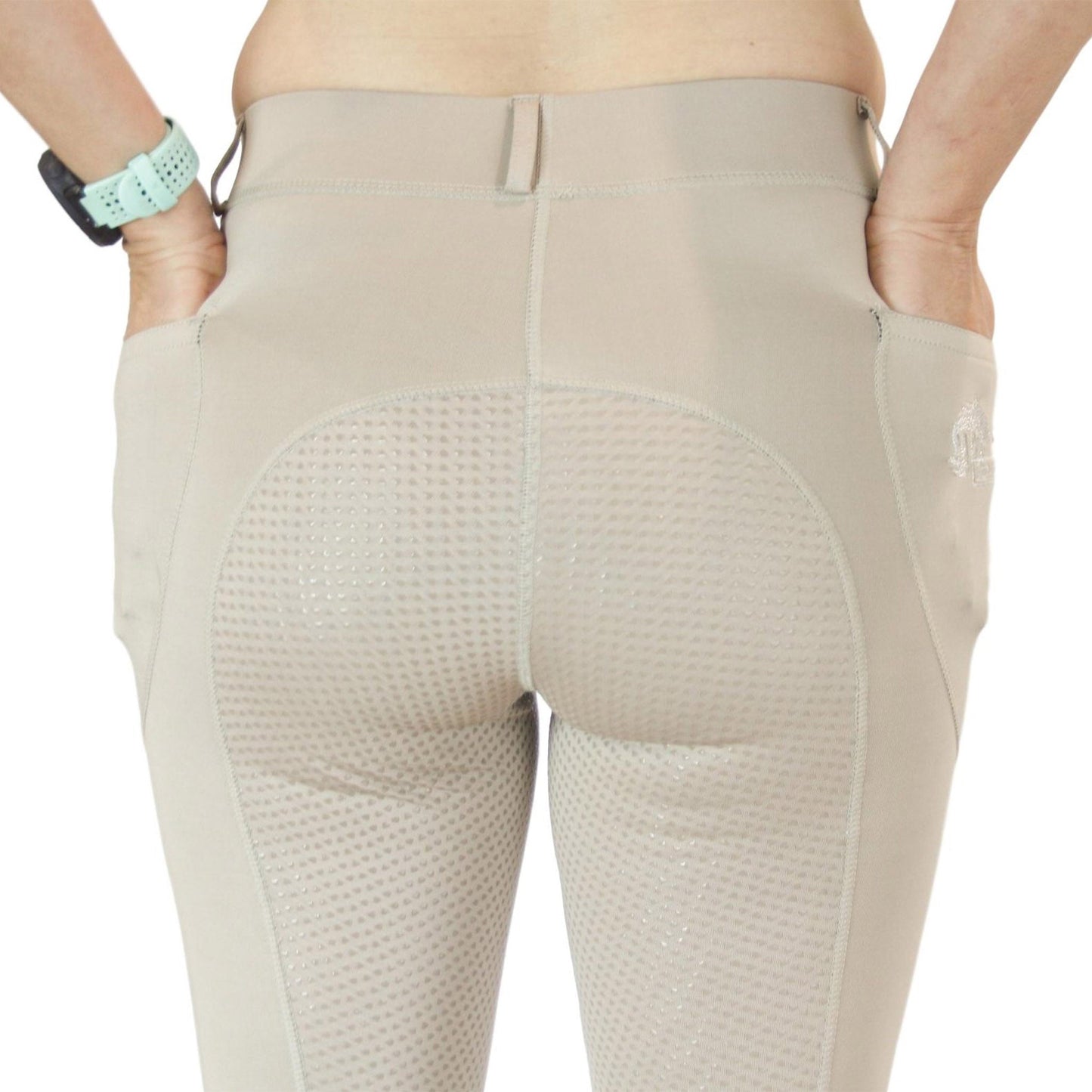 Close-up of beige horse riding tights with mesh details.