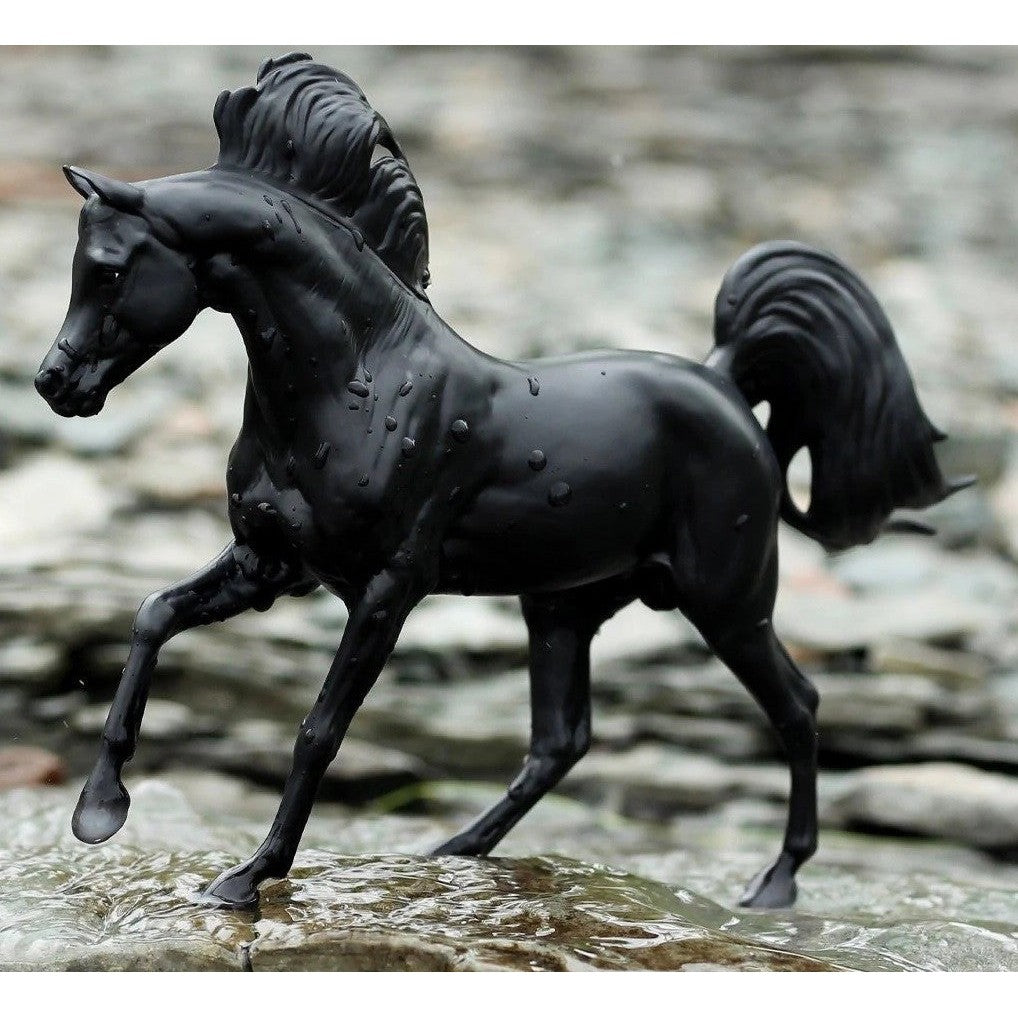 Breyer Horse Toys black model horse prancing on rocky ground.