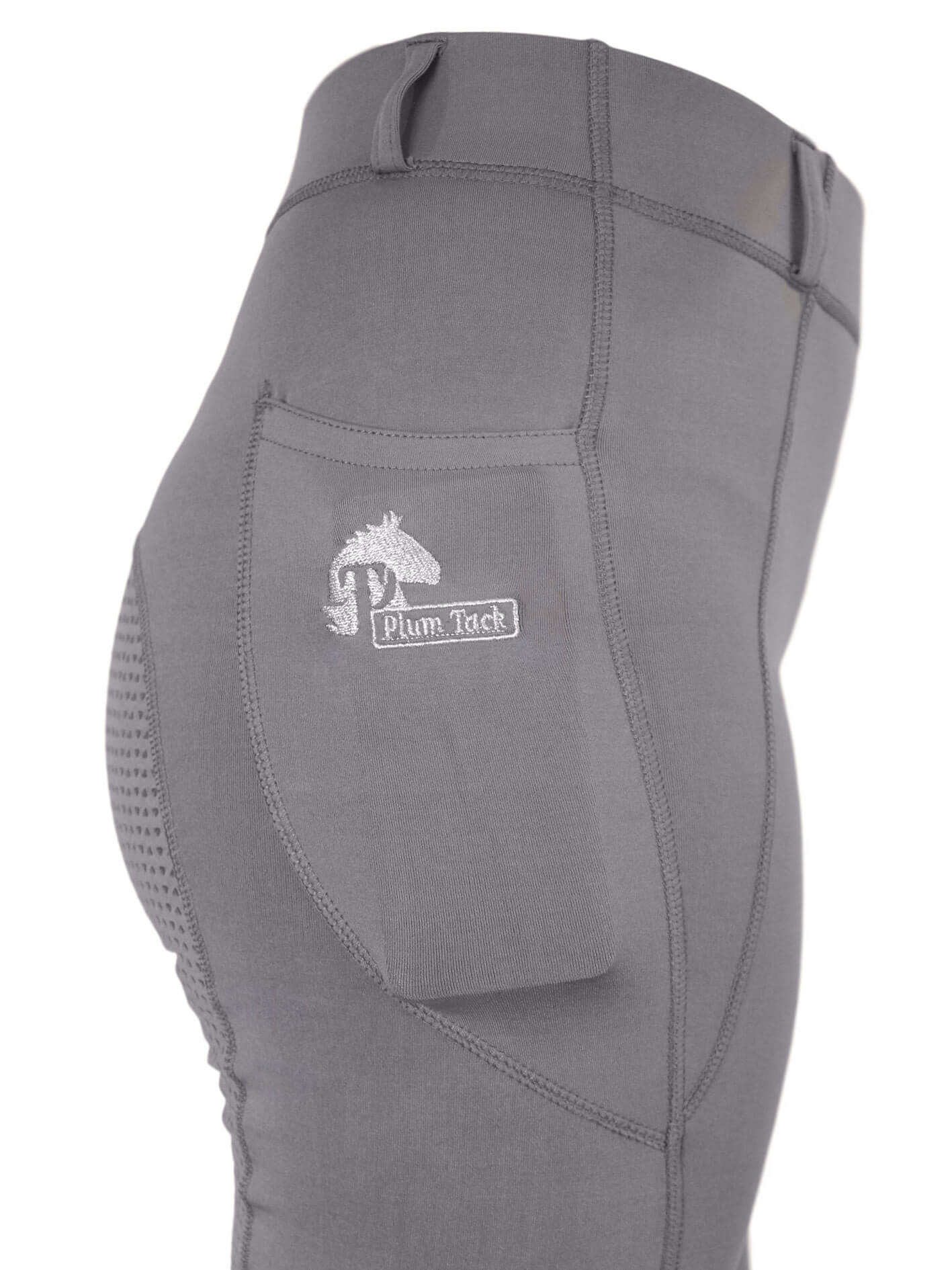 Close-up of gray horse riding tights with Plum Tack logo.