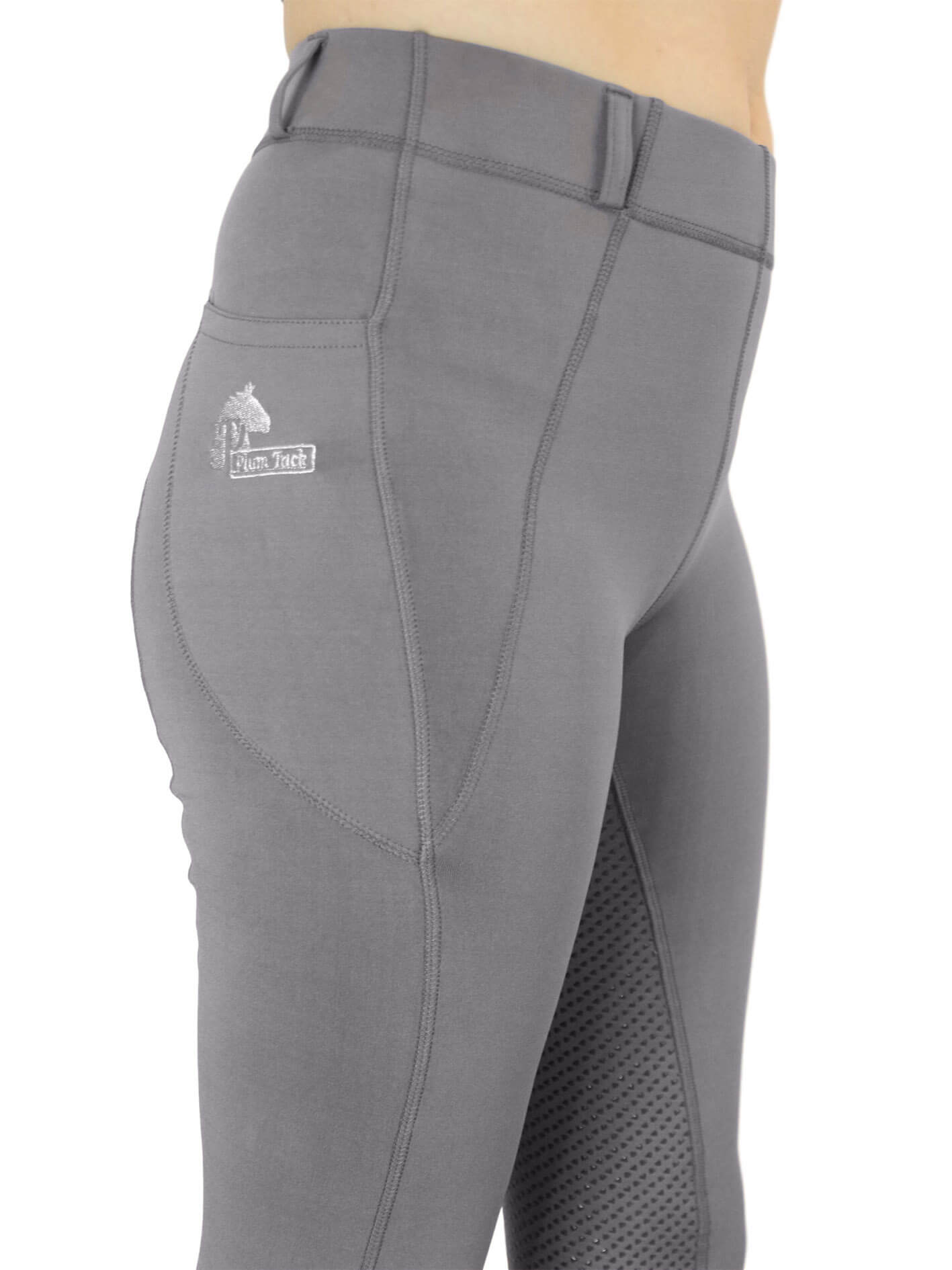 Person wearing gray horse riding tights with a logo on them.
