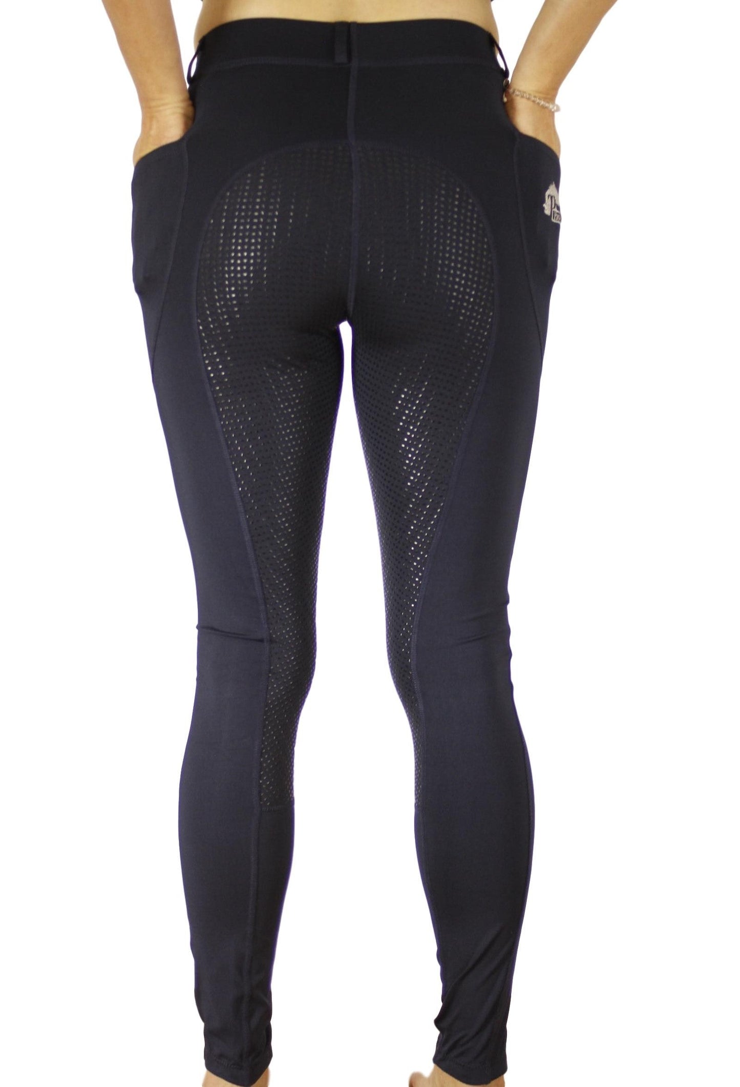 Person standing wearing black horse riding tights with grip patterns.