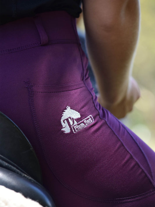Close-up of purple horse riding tights with embroidered logo.