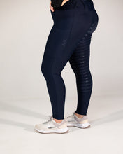 Person wearing navy leggings with a textured pattern on a white background