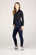 Woman wearing a black long-sleeve top and navy leggings on a white background