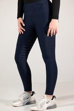 Person wearing navy leggings with text pattern and black long-sleeve top on a light gray background