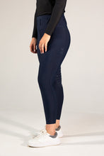 Navy riding pants worn by a person on a white background