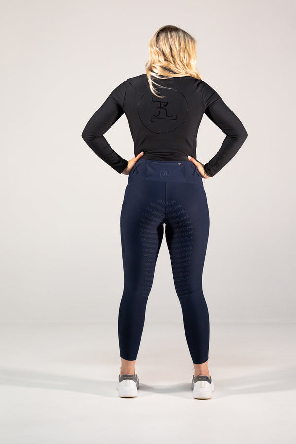 Person wearing navy leggings and a black long-sleeve top with a logo on a white background