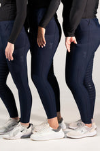 Three people wearing navy blue leggings with a subtle pattern on a light gray background