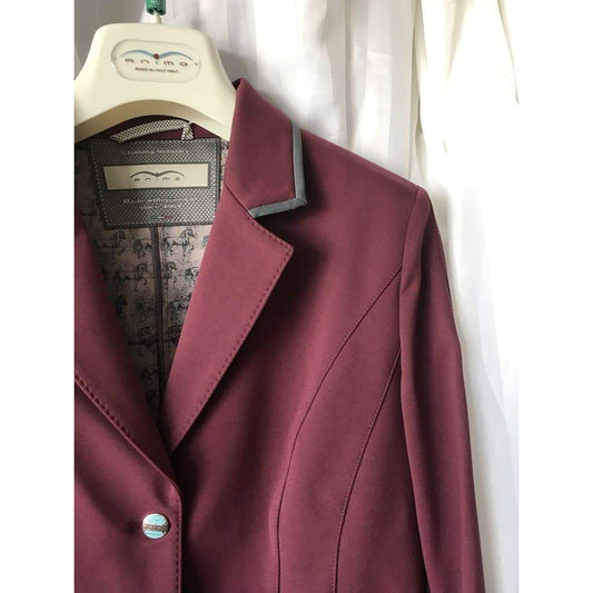 Animo brand maroon equestrian jacket on a hanger with label.