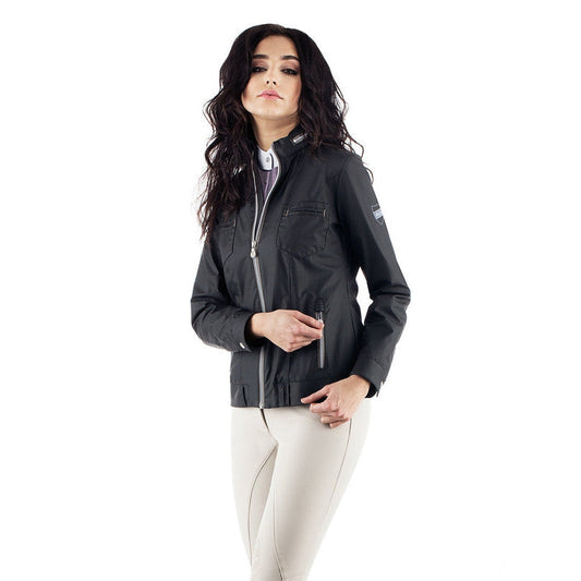Woman modeling black Animo brand equestrian jacket with zipper details.