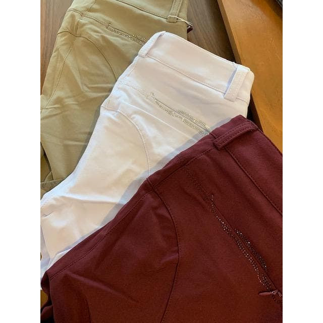 Animo brand equestrian riding breeches in beige, white, and maroon colors.