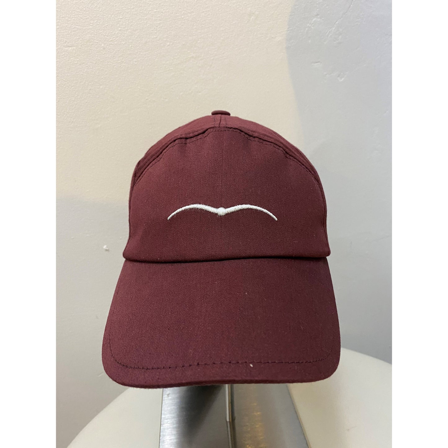 Animo brand maroon baseball cap with white logo on front.
