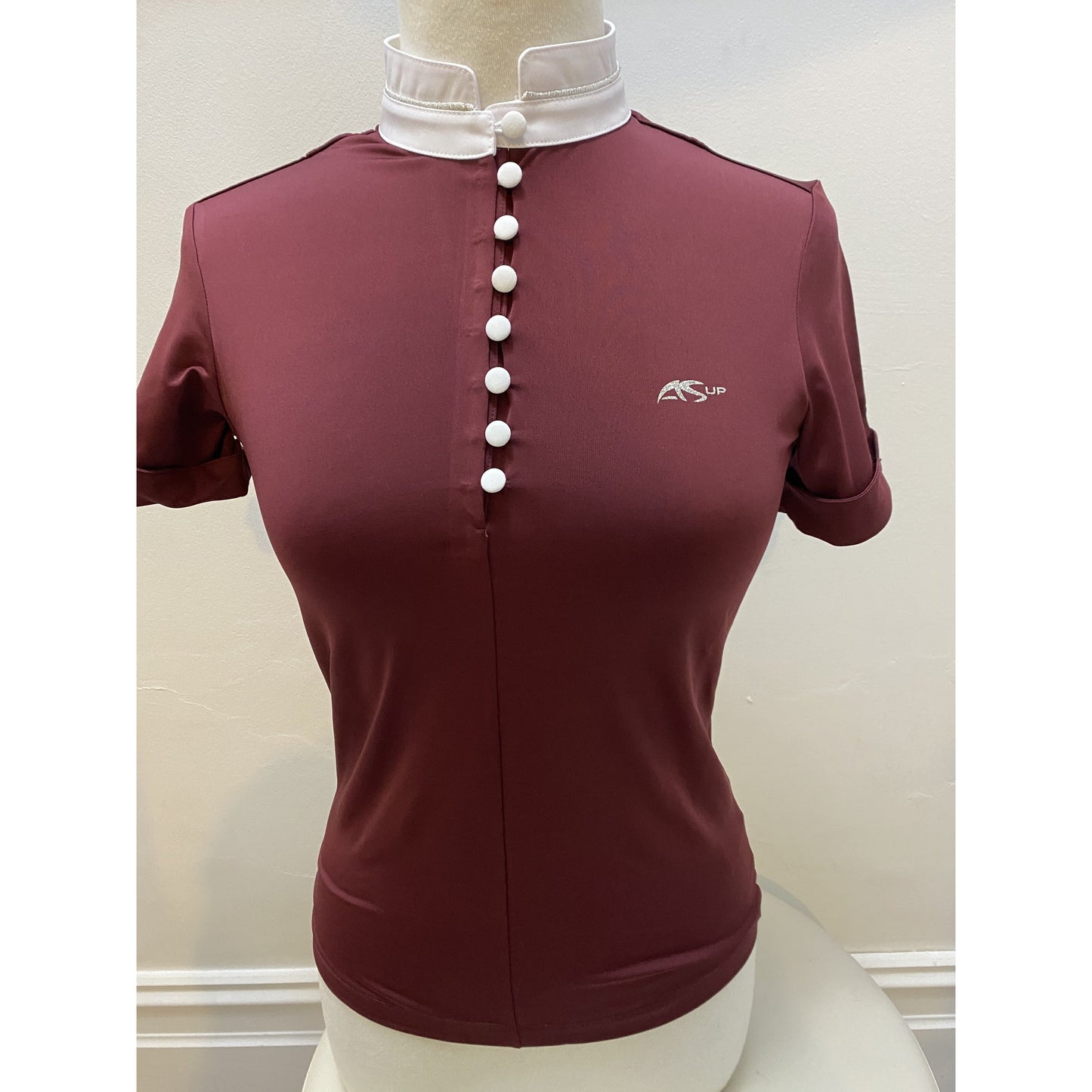 Anna Scarpati burgundy polo shirt with white buttons on mannequin.