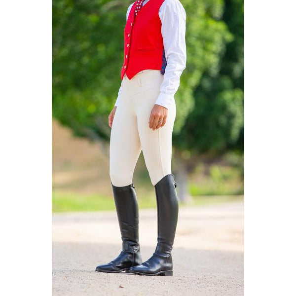 Person in red waistcoat and beige horse riding tights with boots.