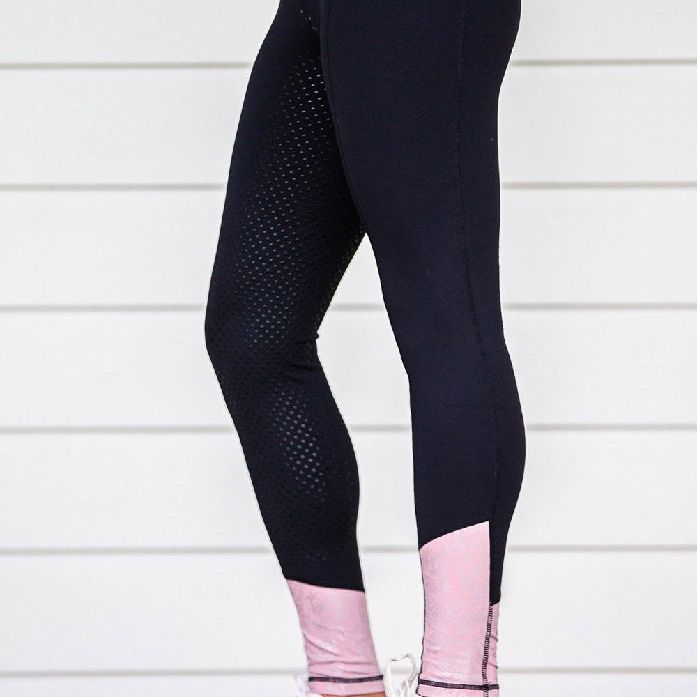 Person wearing black horse riding tights with dotted pattern.