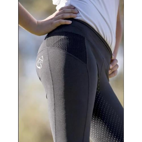 Close-up of gray horse riding tights on a person outdoors.
