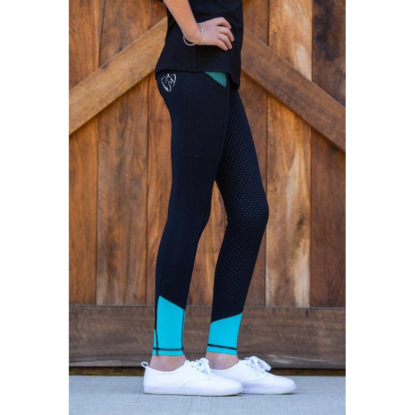 Woman standing in black and turquoise horse riding tights.