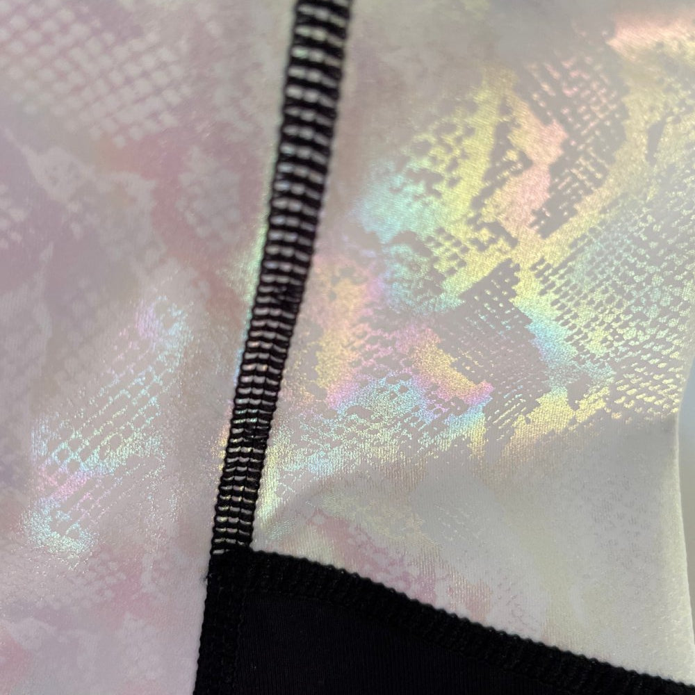 Close-up of iridescent fabric on horse riding tights with seam detail.