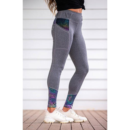 Person in grey horse riding tights with colorful ankle accents.