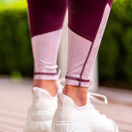 Close-up of stylish purple and white horse riding tights with sneakers.