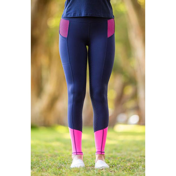 Person standing outside wearing navy horse riding tights with pink accents.