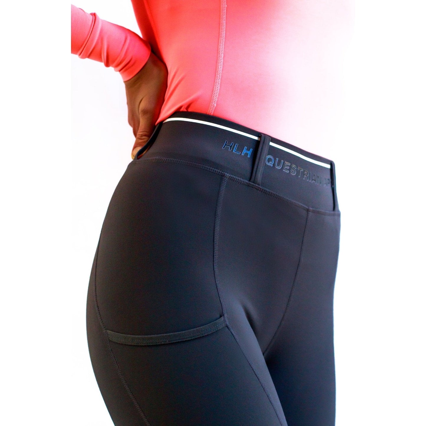 Person wearing black horse riding tights with branding on waistband.