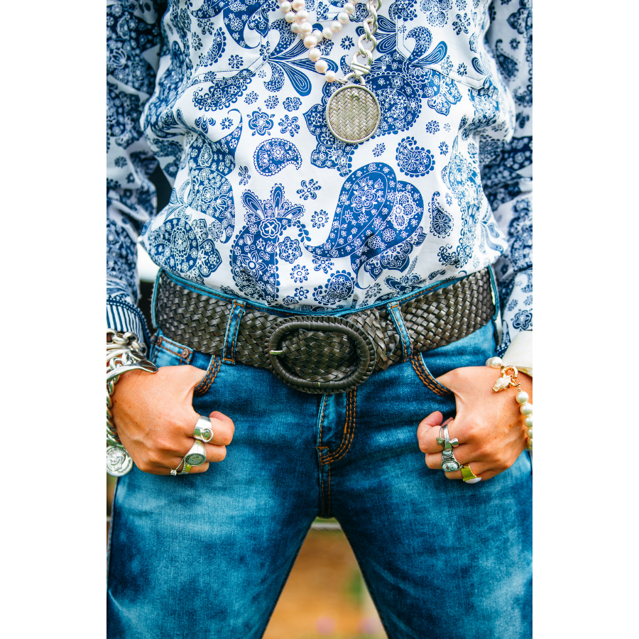 Patterned shirt, jeans, and belt.