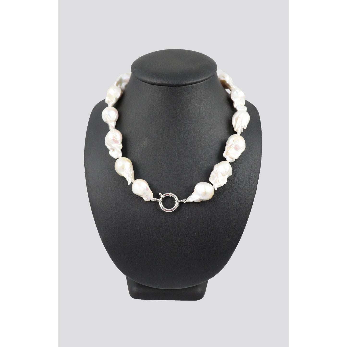 Pearl necklace on black mannequin.