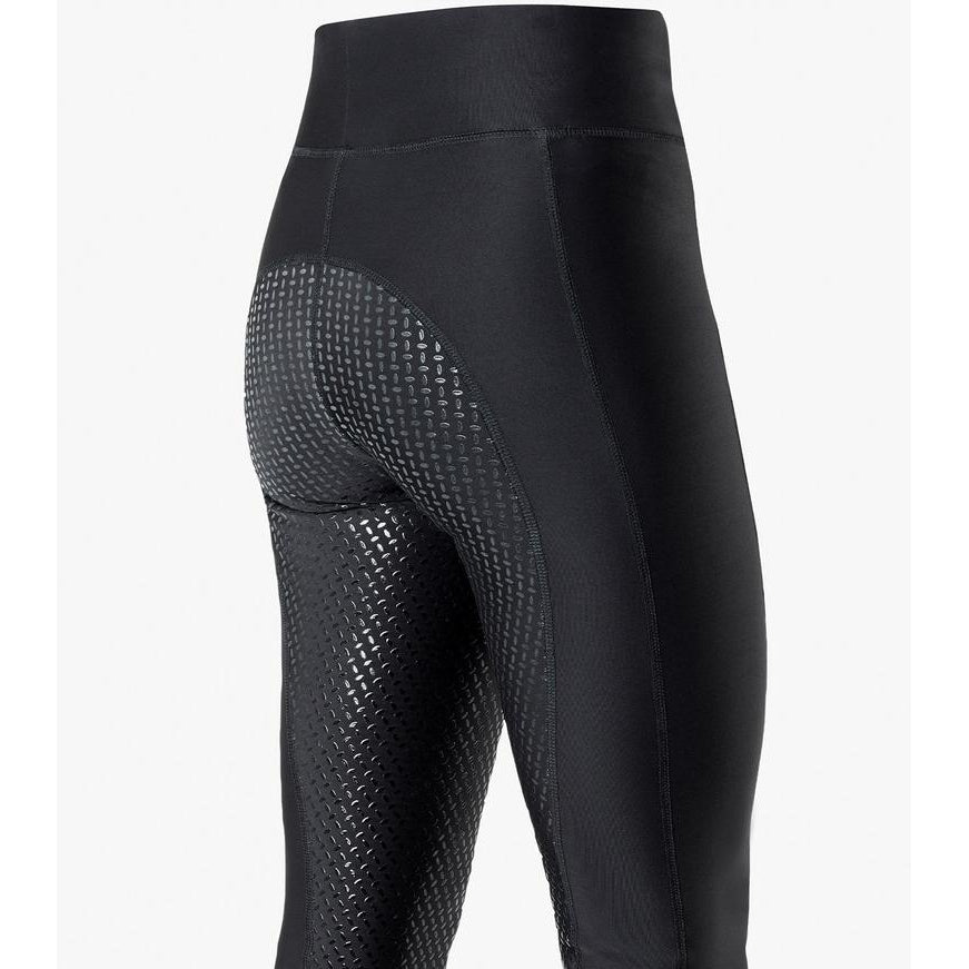 Close-up of black textured horse riding tights with grip pattern.