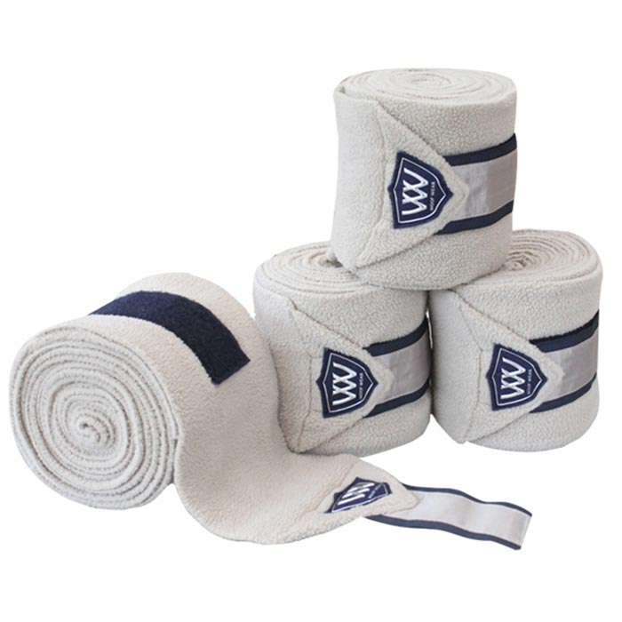 Alt text: Four rolled Woof Wear horse polo wraps in cream and navy.