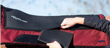 Hands holding and adjusting Thinline horse saddle pad insert.