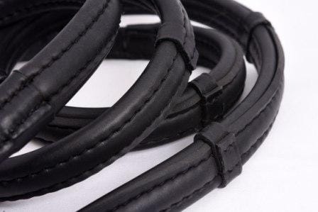 Close-up of Thinline black leather reins with detailed stitching.