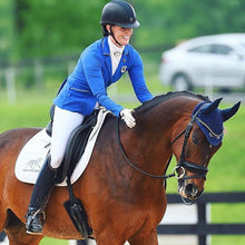 Equestrian in blue jacket riding a horse with Thinline saddlepad.
