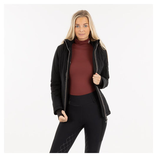 Woman in ANKY black jacket and maroon turtleneck standing confidently.