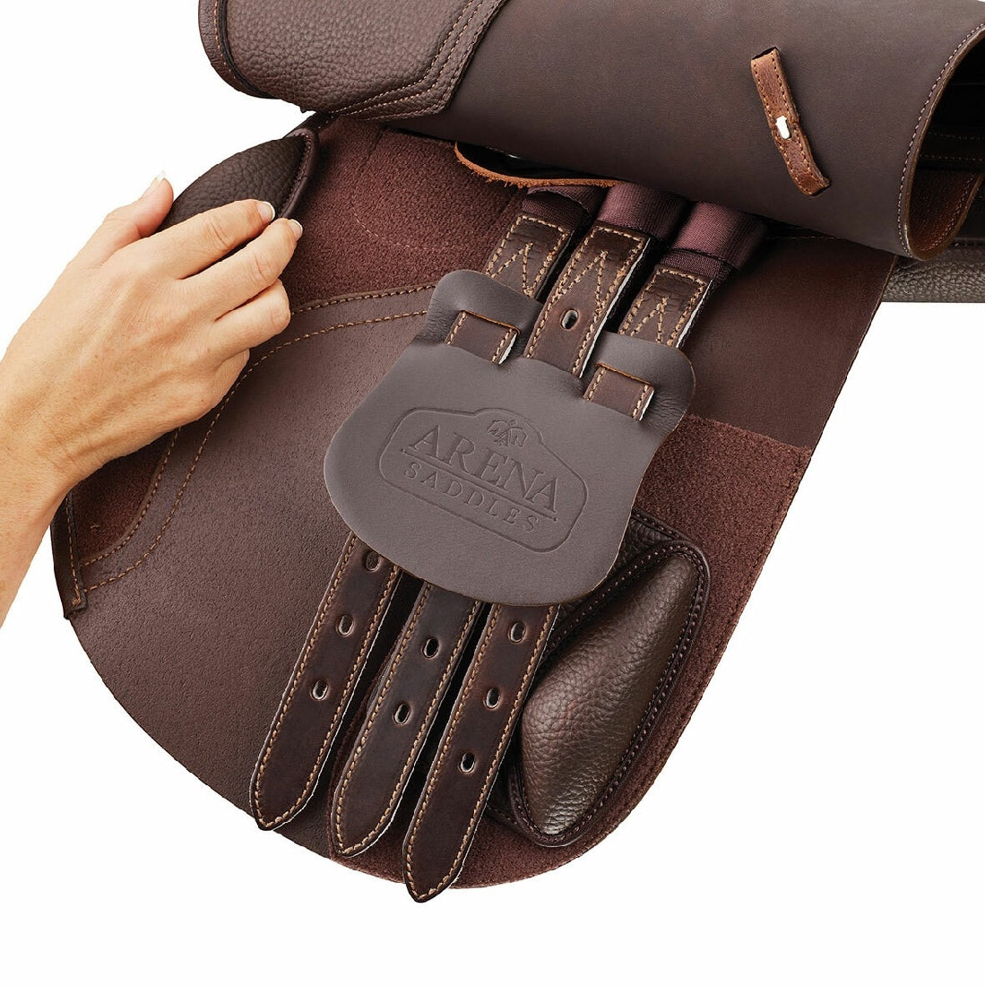 Hand holding Arena Saddles brown leather equestrian saddle detail.