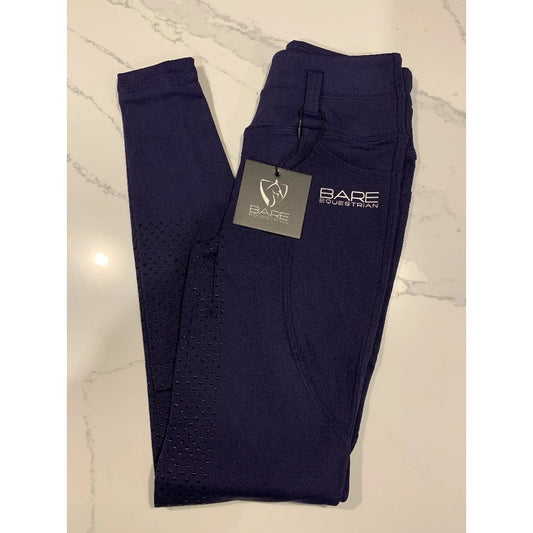 Navy blue horse riding tights laid on marble surface with tag.