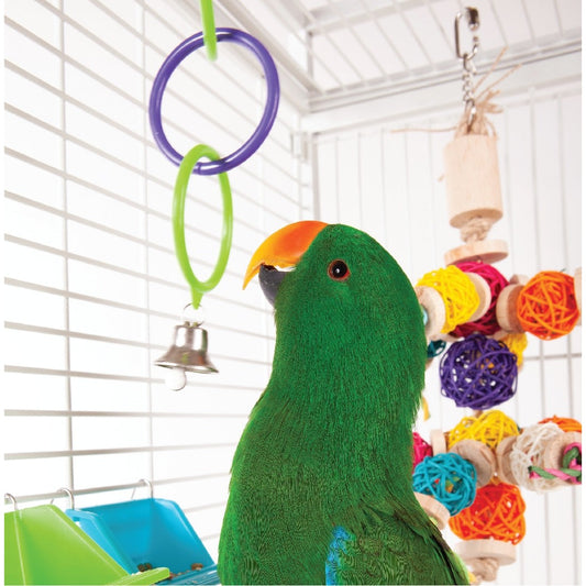 Green plush parrot toy in cage with colorful hanging toys.