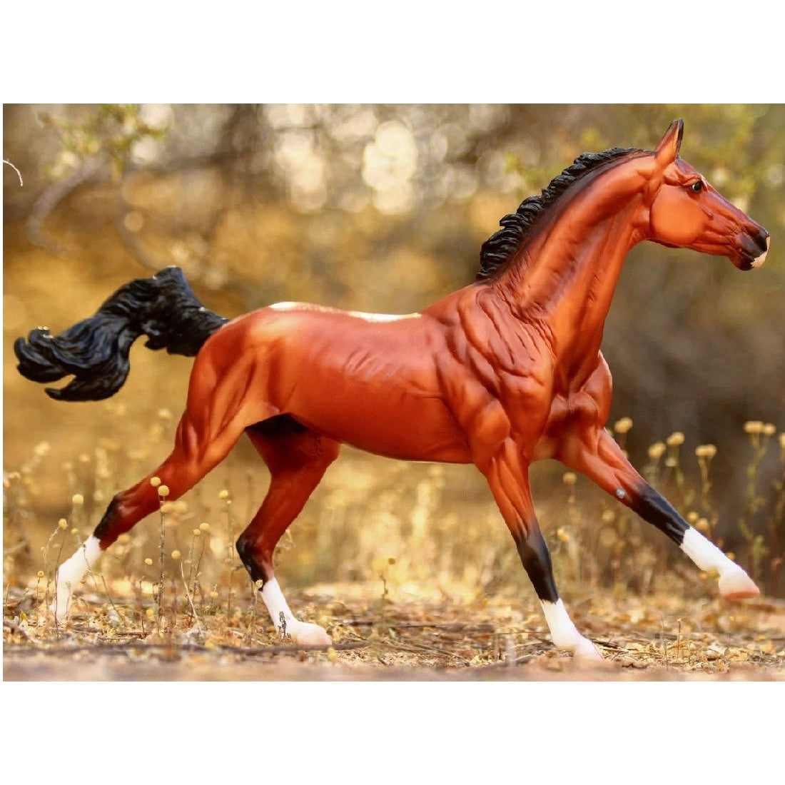 Breyer Horse Toys plastic model posing dynamically in natural background.