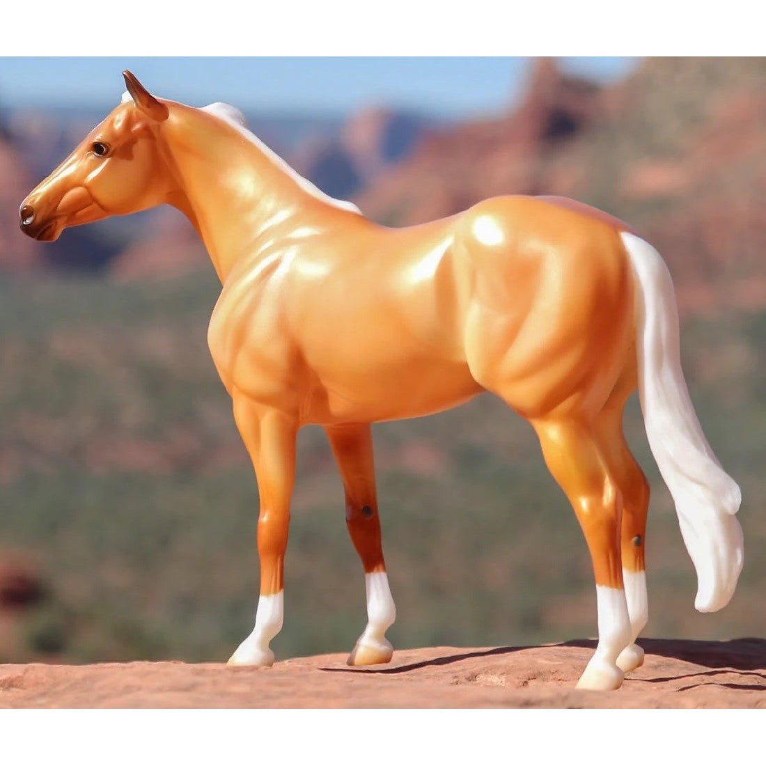 Anna Scarpati model horse figurine against a blurred desert backdrop.