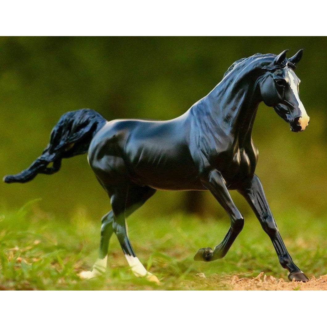 Black Breyer Horse Toy galloping in a natural outdoor setting.