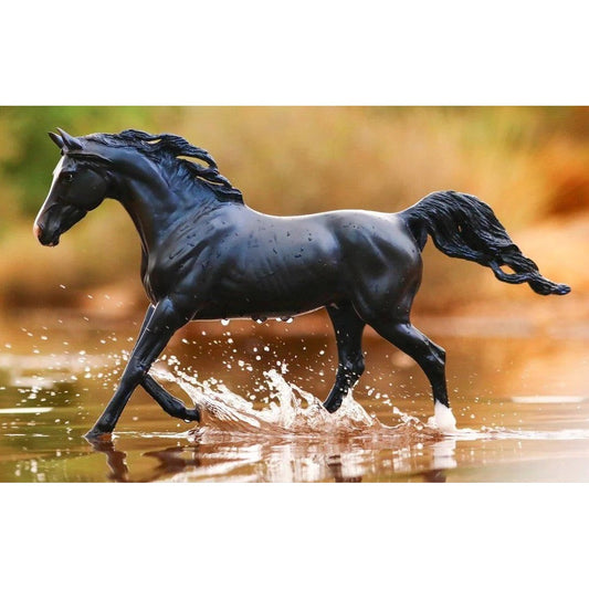 Breyer Horse Toys black model horse galloping through water.