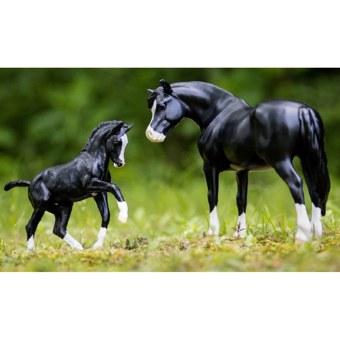 Black Breyer Horse Toys mare and foal in naturalistic outdoor setting.