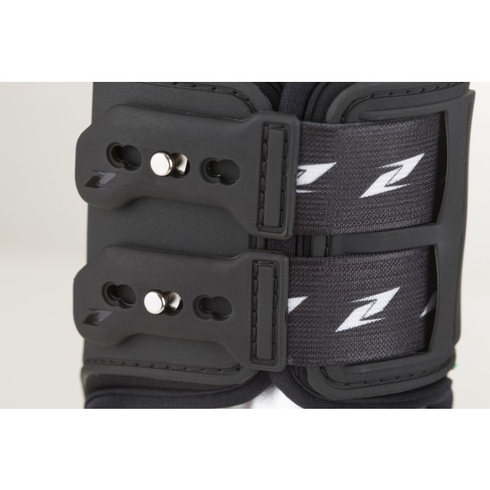 Close-up of black Zandona horse boots with secure straps and logo.