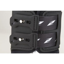 Close-up of black Zandona horse boots with secure straps and logo.